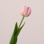 Pink faux tulip stem with soft gradient petals and realistic green foliage suitable for wedding or event floral styling