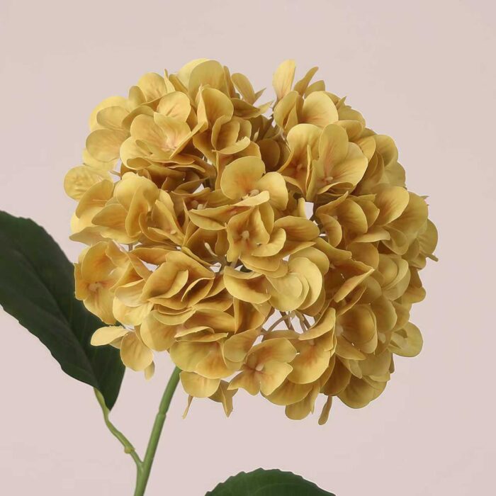 Mustard yellow faux hydrangea stem with textured petals and realistic foliage, suitable for wedding decor and event floral arrangements