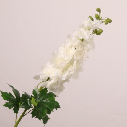 White faux delphinium spray with layered soft petals and realistic foliage suited for wedding decor and elegant event floral arrangements.