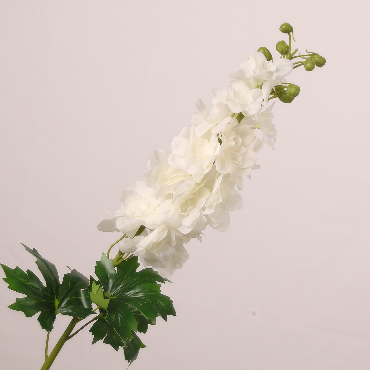 White faux delphinium spray with layered soft petals and realistic foliage suited for wedding decor and elegant event floral arrangements.