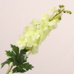 Light green faux delphinium spray with soft petals and lifelike leaves ideal for wedding decor and event floral arrangements.
