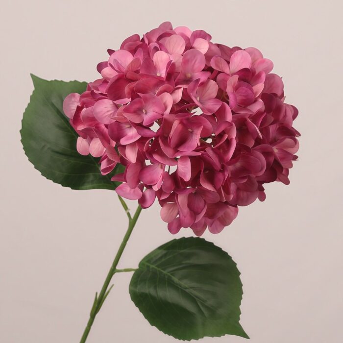Dark pink faux hydrangea stem with dense layered petals and natural leaves, ideal for wedding decor and event floral arrangements