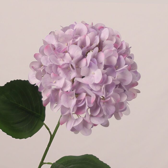 Lavender faux hydrangea stem with soft pastel petals and realistic foliage, perfect for wedding decor and elegant event styling