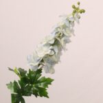 Ivory faux delphinium spray with soft neutral petals and natural green foliage perfect for wedding decor and elegant event floral arrangements.