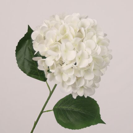 White faux hydrangea stem with full layered petals and natural leaves, ideal for wedding decor and elegant event styling