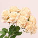 Champagne faux rose bouquet with layered petals and lush greenery ideal for wedding decor or elegant event arrangements