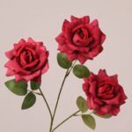 Red faux rose spray with three full blooms and realistic veined petals, suitable for wedding decor and event floral arrangements