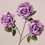 Purple faux rose spray with soft gradient petals and natural green leaves for wedding and event floral decor