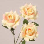 Cream yellow faux rose spray with soft petal layers and natural texture for wedding and event decor