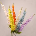 Mixed color faux delphinium stems arranged together with layered petals for wedding decor and event floral arrangements