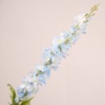 Light blue faux delphinium stem with layered petals and realistic leaves for wedding decor and event floral arrangement