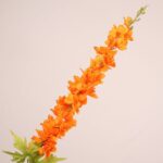 Vibrant orange faux delphinium stem with dense layered petals and lifelike greenery for wedding decor and event floral use