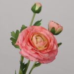 Coral pink artificial ranunculus flower with layered petals and natural leaves