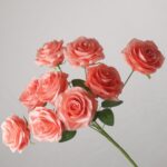 Coral pink faux rose bouquet with soft layered petals for wedding decor and vibrant event floral arrangement design