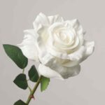 Detailed close-up of a premium, real-touch artificial white rose bloom with multi-layered petals and dark green foliage.