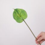 A single stem of a vibrant, all-green artificial anthurium flower, featuring a textured green spathe and spadix.
