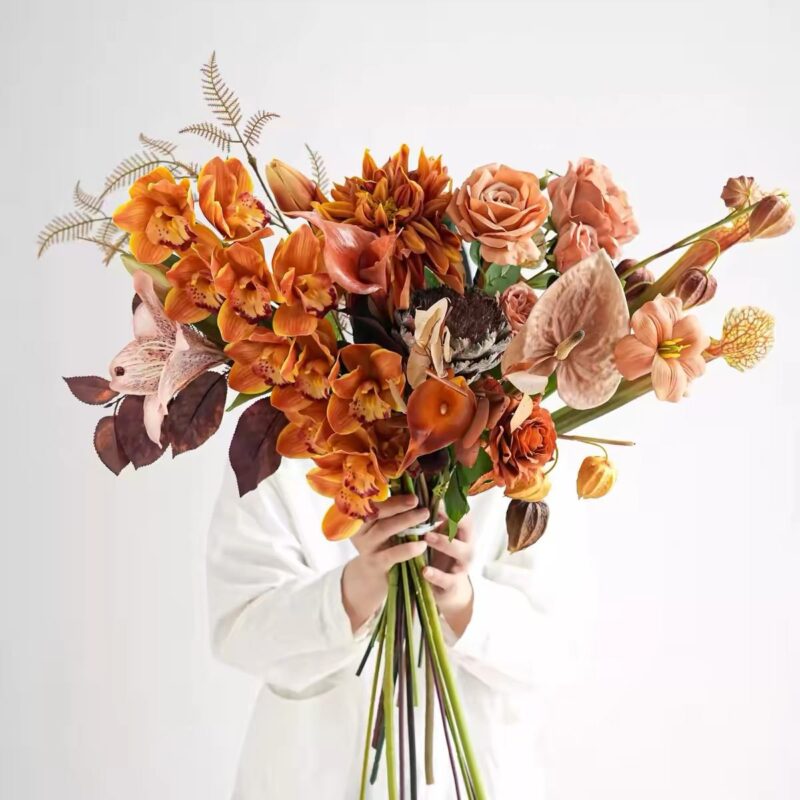 Orange and pink floral arrangement with orchids, roses, and anthuriums