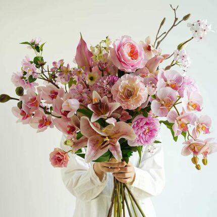 Pink floral arrangement with lilies, roses, orchids, and peonies