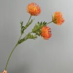 Three realistic orange artificial pincushion flower blooms for wedding or home decor arrangements.