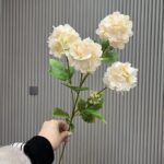 Artificial silk hydrangea bouquet with four creamy white flower heads and green foliage.