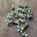 Artificial silk lilac flower sprays arranged on gray background