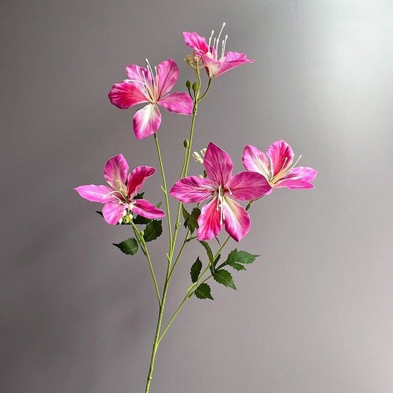 Realistic artificial pink silk lilies arranged on green stems for home floral décor.