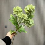 Realistic artificial silk hydrangea bouquet with four large heads and lush green leaves.