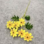 Cluster of artificial yellow silk daisies with green leaves for durable floral arrangements