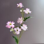 Cluster of artificial pink silk-butterfly peonies on green stems for decor.