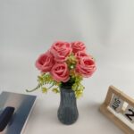 Artificial pink silk rose bouquet with greenery arranged in a gray vase