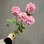 Artificial silk hydrangea bouquet with four pink blooms and green foliage.