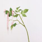 Artificial hanging wisteria flowers with pink blooms and green leaves for home decor.
