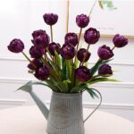 Elegant arrangement of deep purple artificial silk tulips in a decorative vase.