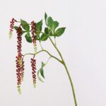 Artificial hanging floral bouquet featuring cascading clusters of deep red and light green blossoms.