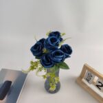 Blue silk rose bouquet with green foliage arranged in a vase