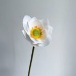 Beautiful artificial white silk lotus bloom centerpiece decoration on a stem.