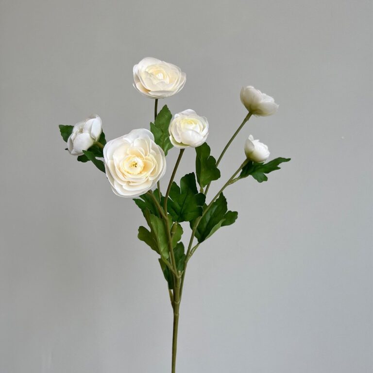 Artificial silk lotus and rose blossoms arrangement on stems with green leaves.