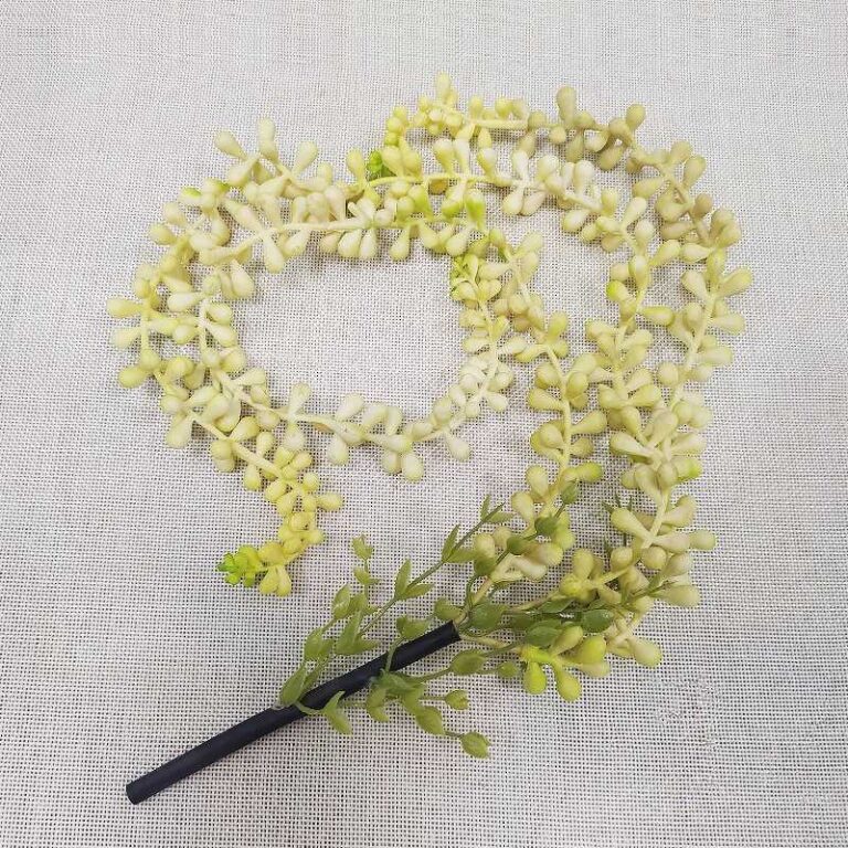 Artificial PVC hanging flower garland in pale green and cream, perfect for elegant wedding decor.