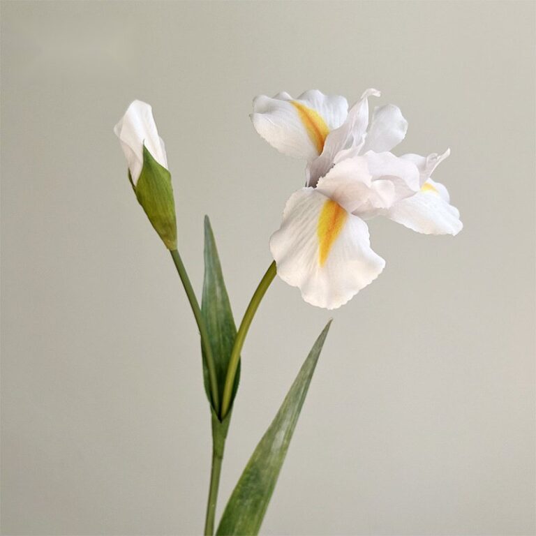 Realistic artificial white and yellow irises, showing both an open bloom and a fresh bud.