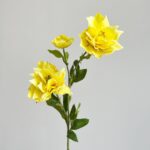 Yellow silk clematis flower arrangement featuring three vibrant blooms on leafy stems.