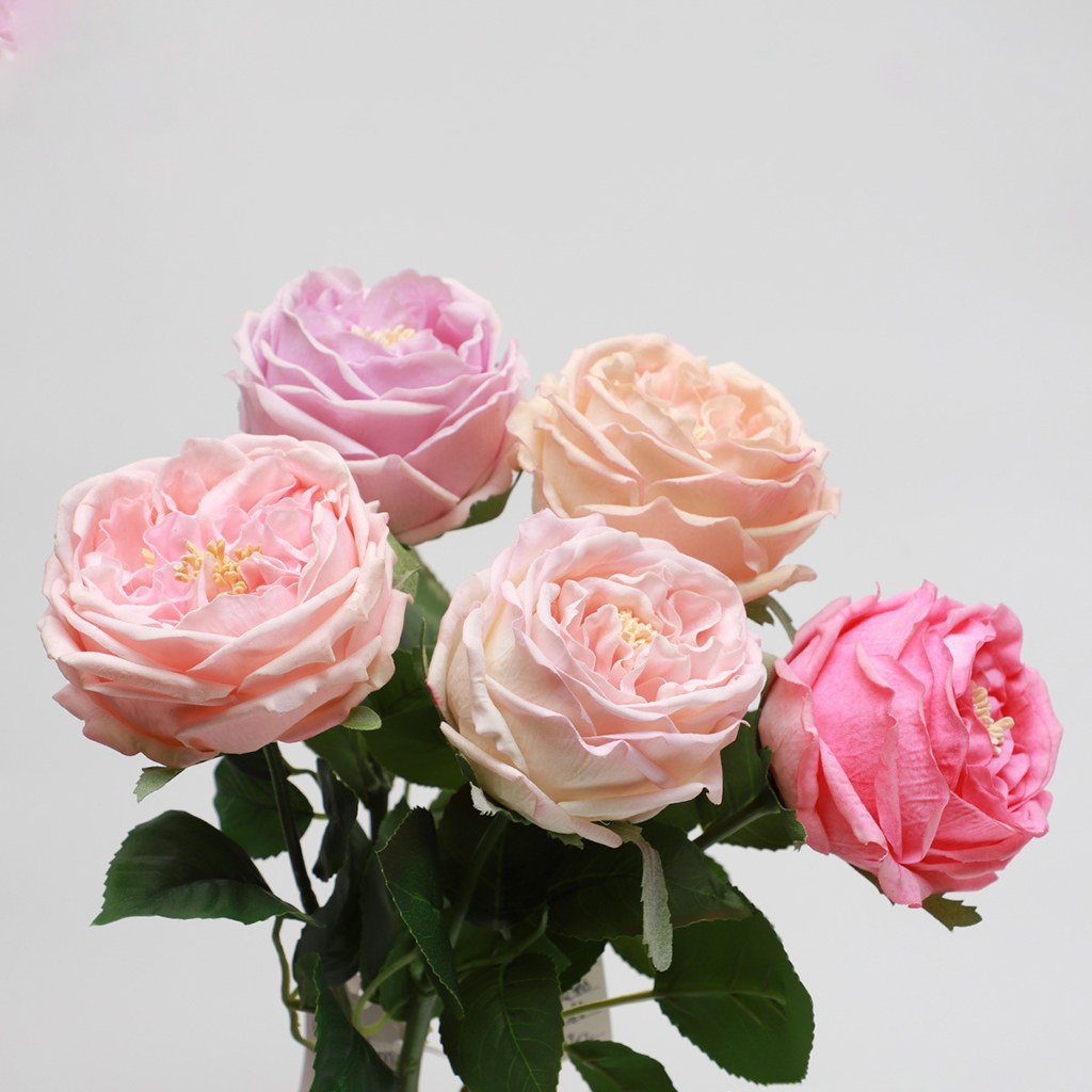 Realistic faux bouquet of pink artificial roses suitable for weddings or home accents.