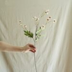Silk vintage daisy artificial flower bouquet held by hand, perfect for home decor and crafts.