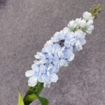 Delicate light blue artificial delphinium flower spray with green leaves