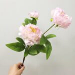 Three artificial blush pink peonies with green leaves, ideal for fake floral arrangements and home decor.