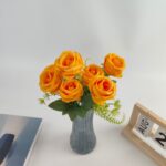 Bouquet of 7 artificial orange silk roses displayed in a gray vase.