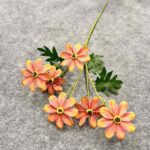 Artificial silk daisy bouquet with orange blooms and green foliage, perfect for crafting.