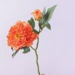 Realistic silk peony bouquet showing two vibrant coral blooms, buds, and leaves.