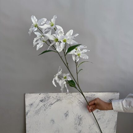 Artificial white lilies branch, featuring 12 realistic fabric flower heads for home decor.