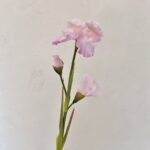 Three artificial pink silk irises arranged vertically against a white background.