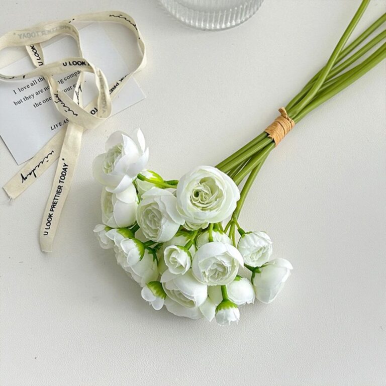 White silk lotus flower bouquet with decorative ribbon on a clean background.